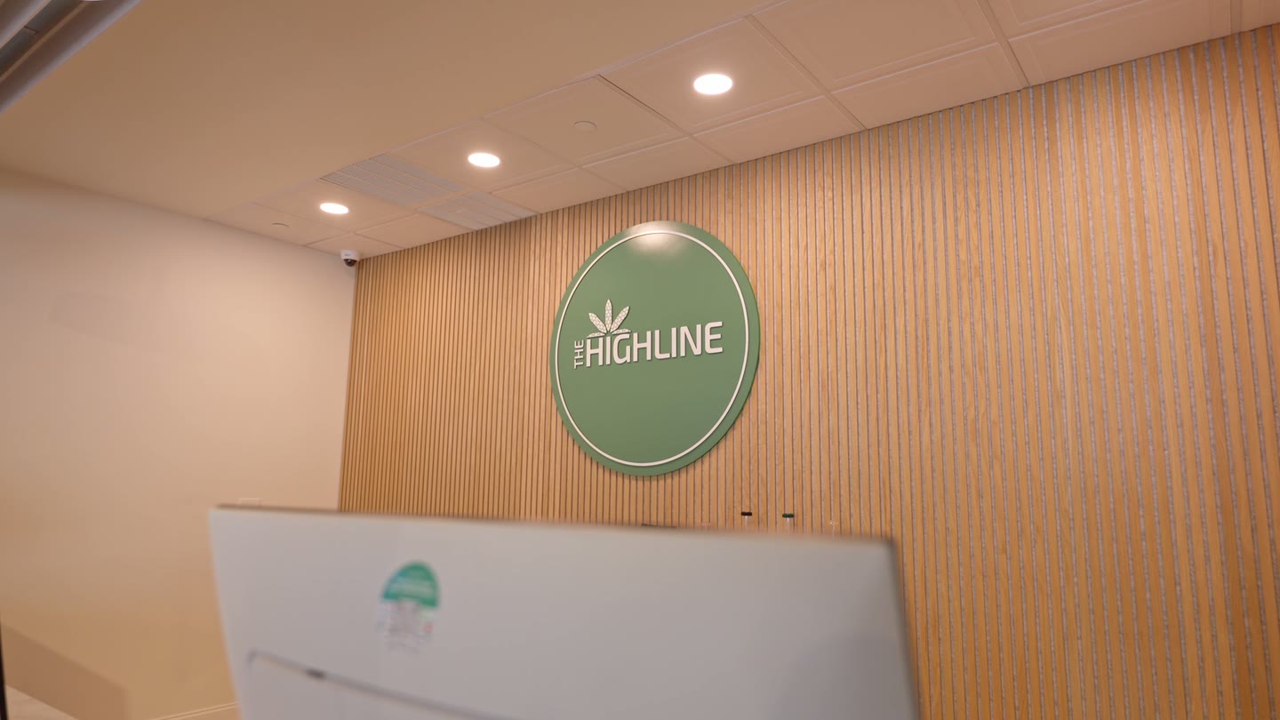 Drone reveal along The Highline's reception counter, slatted wood wall, the circular logo medallion, iPad kiosks at 45 Main Street